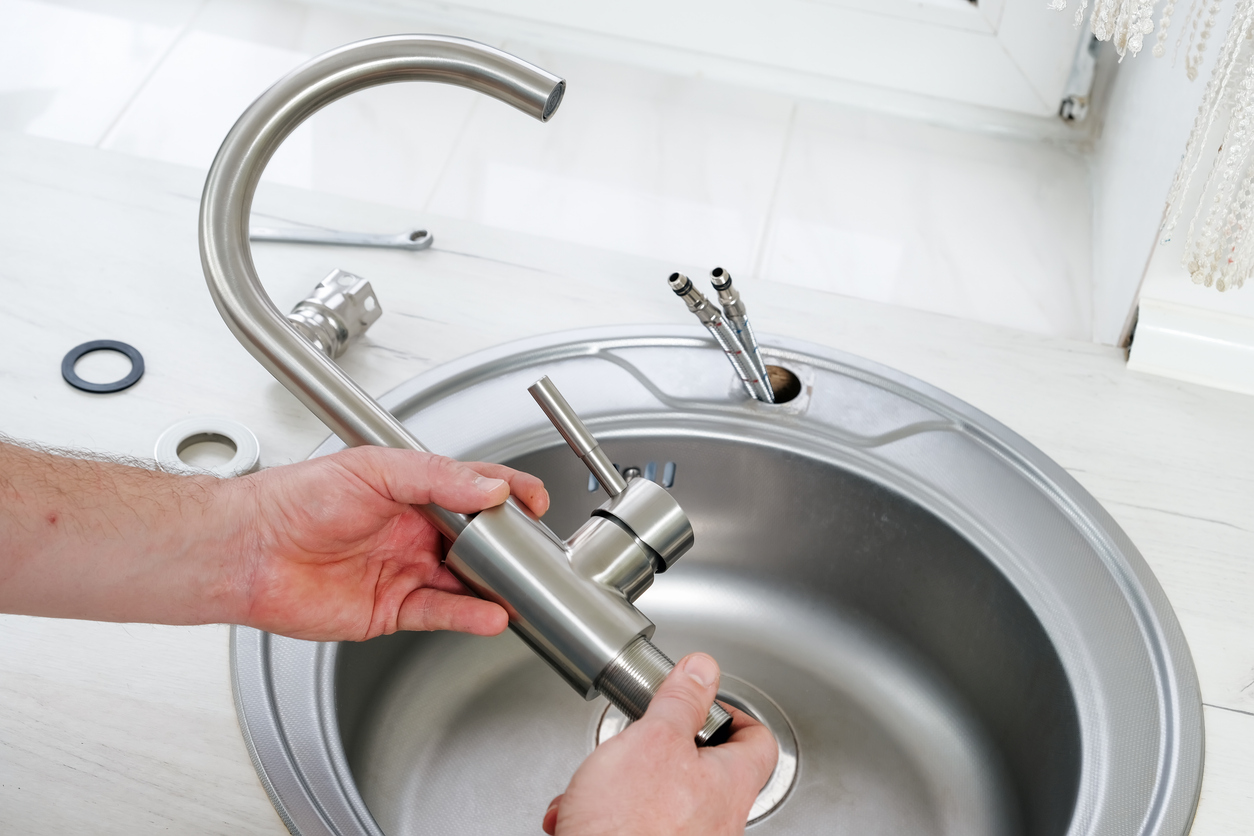 Plumber installing a new faucet on a bathroom sink